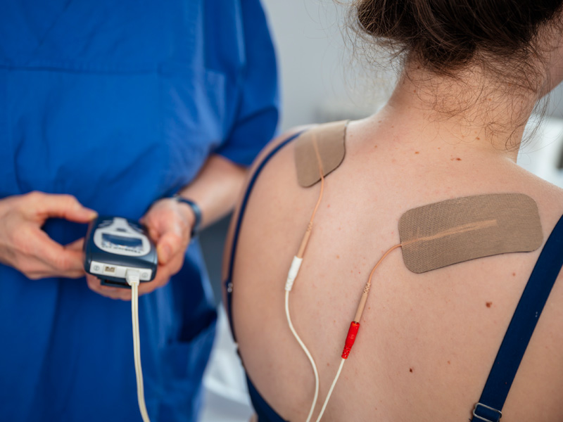 Schmerztherapie am Rücken einer Frau