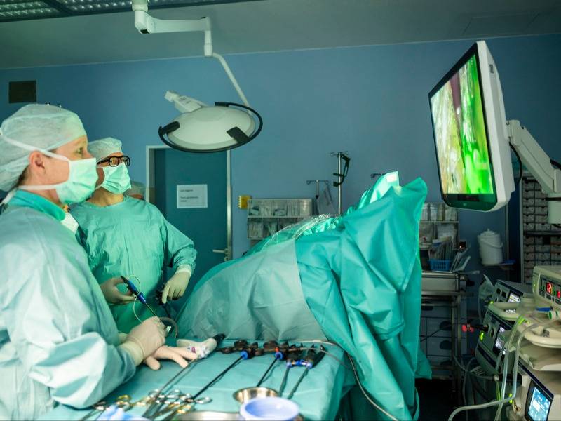 Eine Operation mit Arzt und Ärztin, die auf einen Monitor schauen