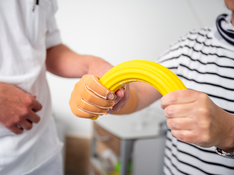 Patient, der kräftigungsübungen nach einer Hand-OP durchführt
